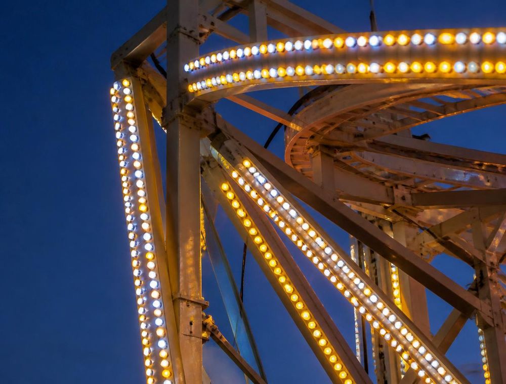 LED-Lichtleisten eines Fahrgeschäfts leuchten in der Dämmerung